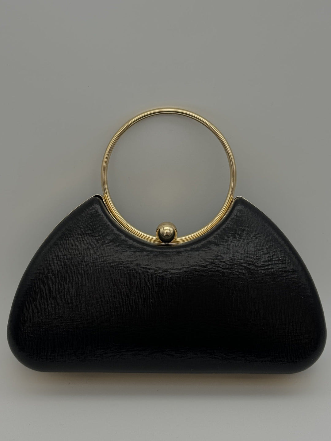 Pochette femme de soirée élégante noire avec cadre métal minimaliste, accessoire chic pour mode soirée.