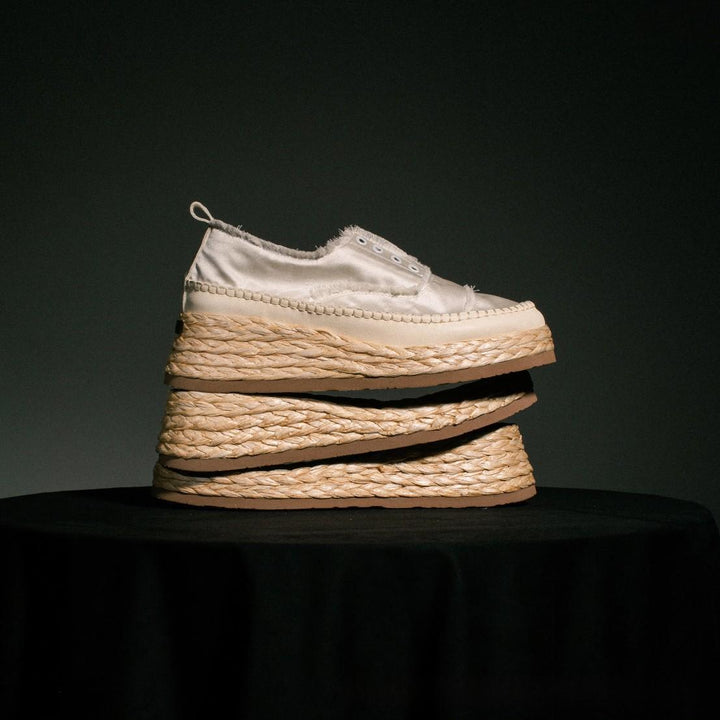 Gros plan sur les finitions effilochées et la semelle espadrille de ces baskets plateforme femme.