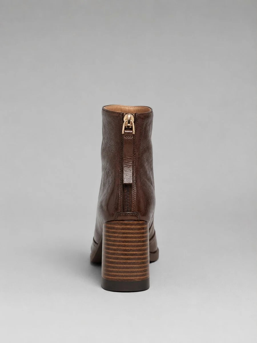 Paire de bottines femme marron foncé, bout carré et talon bloc stable, parfaites pour une tenue chic.