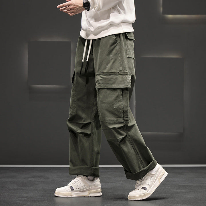 Homme stylé portant un pantalon cargo large, confortable. Taille élastique, poches, style décontracté moderne masculin.