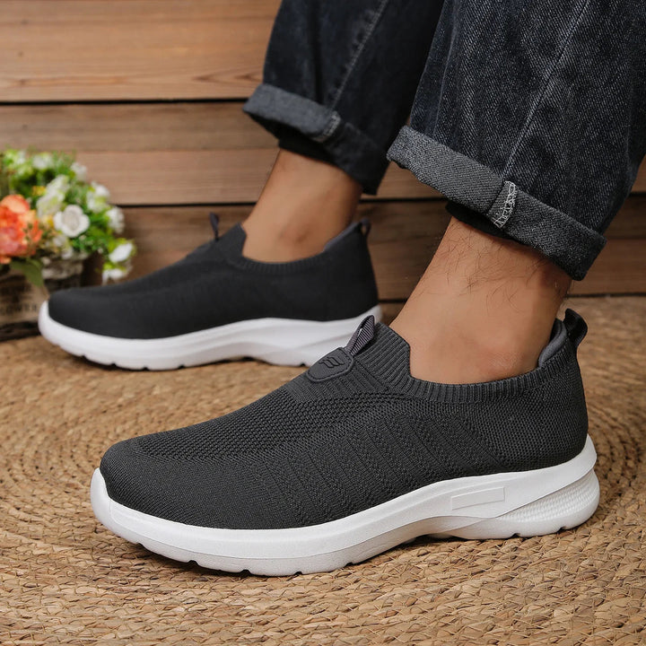 Baskets homme grises, style slip-on minimaliste, offrant un grand confort pour toutes les saisons.