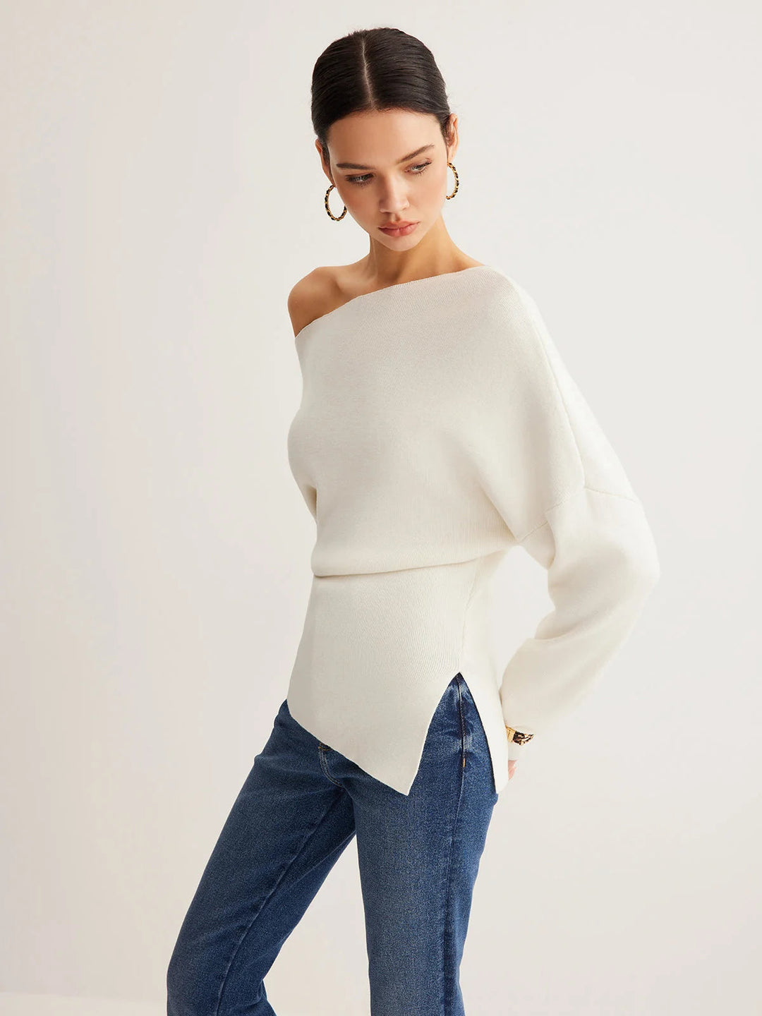 Pull femme élégant noir, épaules dénudées, coupe slim, casual chic.