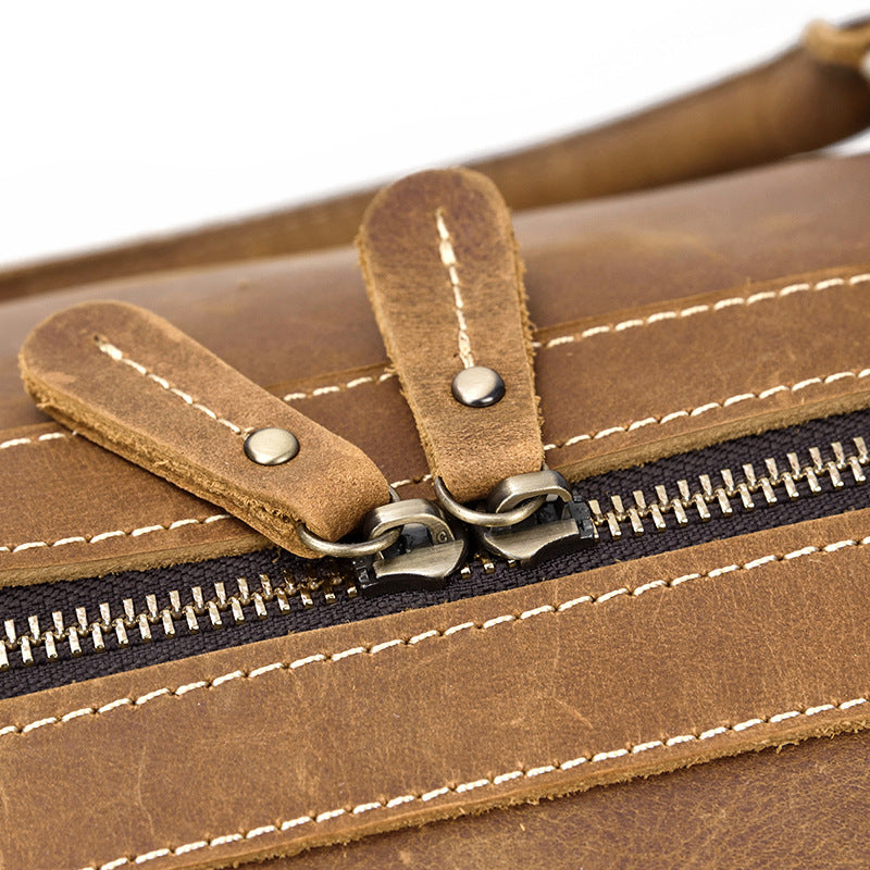 Sac de voyage homme duffel en cuir marron vintage, détails des boucles et fermetures robustes.