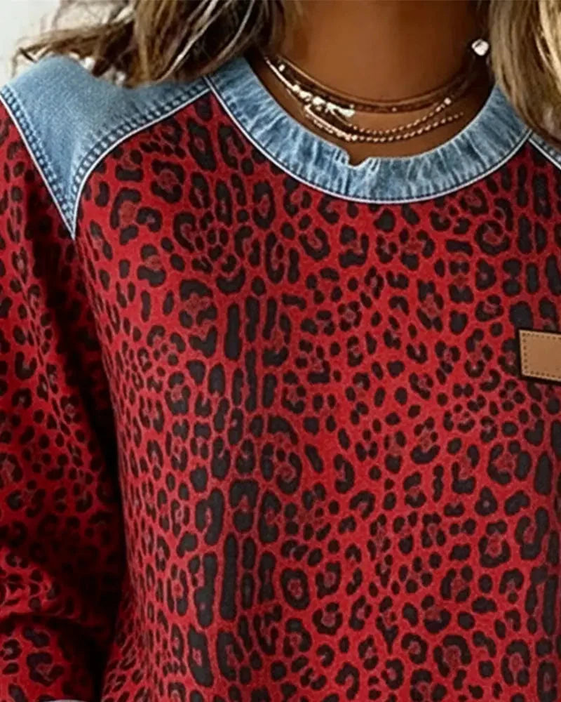 Femme portant un sweatshirt patchwork chic à motif floral, col rond. Tenue automne décontractée.
