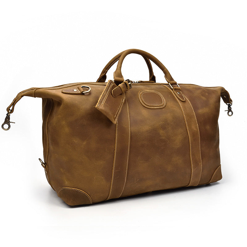 Sac de voyage duffel pour homme en cuir marron vintage, grande capacité, robuste et stylé.