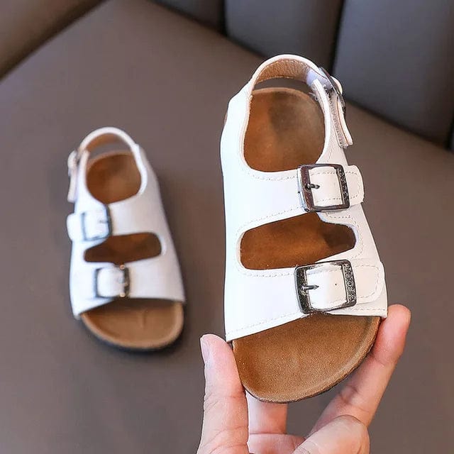 Bébé explorant le jardin avec des sandales respirantes et confortables, parfaites pour l'extérieur.