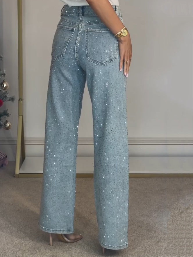 Femme portant un jean taille haute scintillant, coupe ajustée, parfait pour une tenue décontractée ou chic.