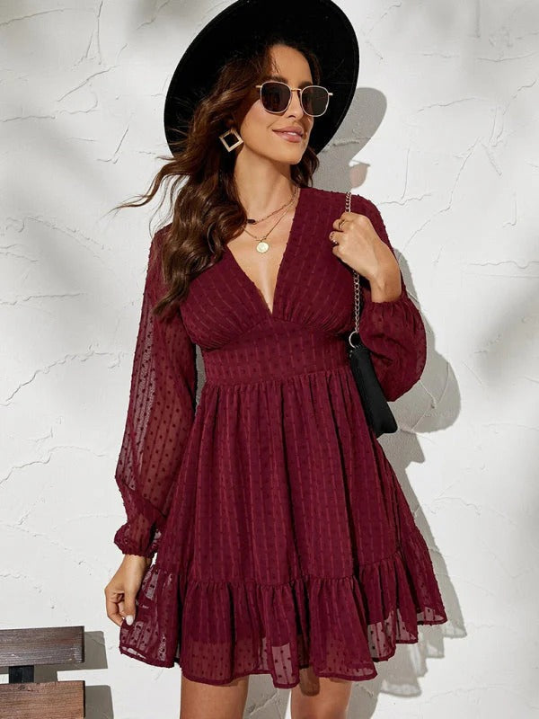 Détail de la robe femme chic à col V et manches longues. Un design moderne pour une silhouette féminine.