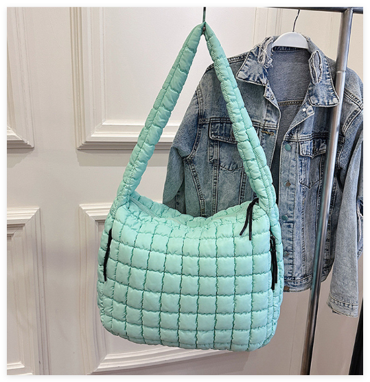 Sac matelassé femme noir avec fermeture éclair et compartiments. Idéal pour organiser vos essentiels mode.