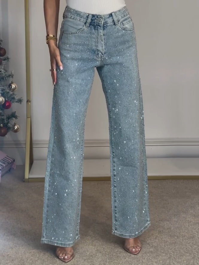 Détail du jean femme taille haute scintillant, effet brillant, denim moderne élégant pour mode féminine.