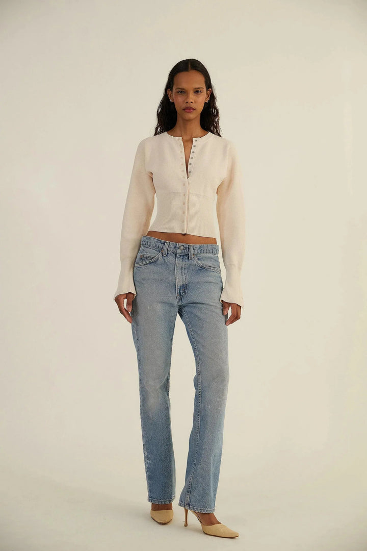 Cardigan femme chic porté, col rond boutonné. Gilet tricot élégant pour une touche quotidienne de mode féminine.