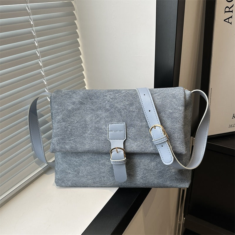 Vue latérale du sac bandoulière femme, structure épurée et élégante en cuir synthétique.
