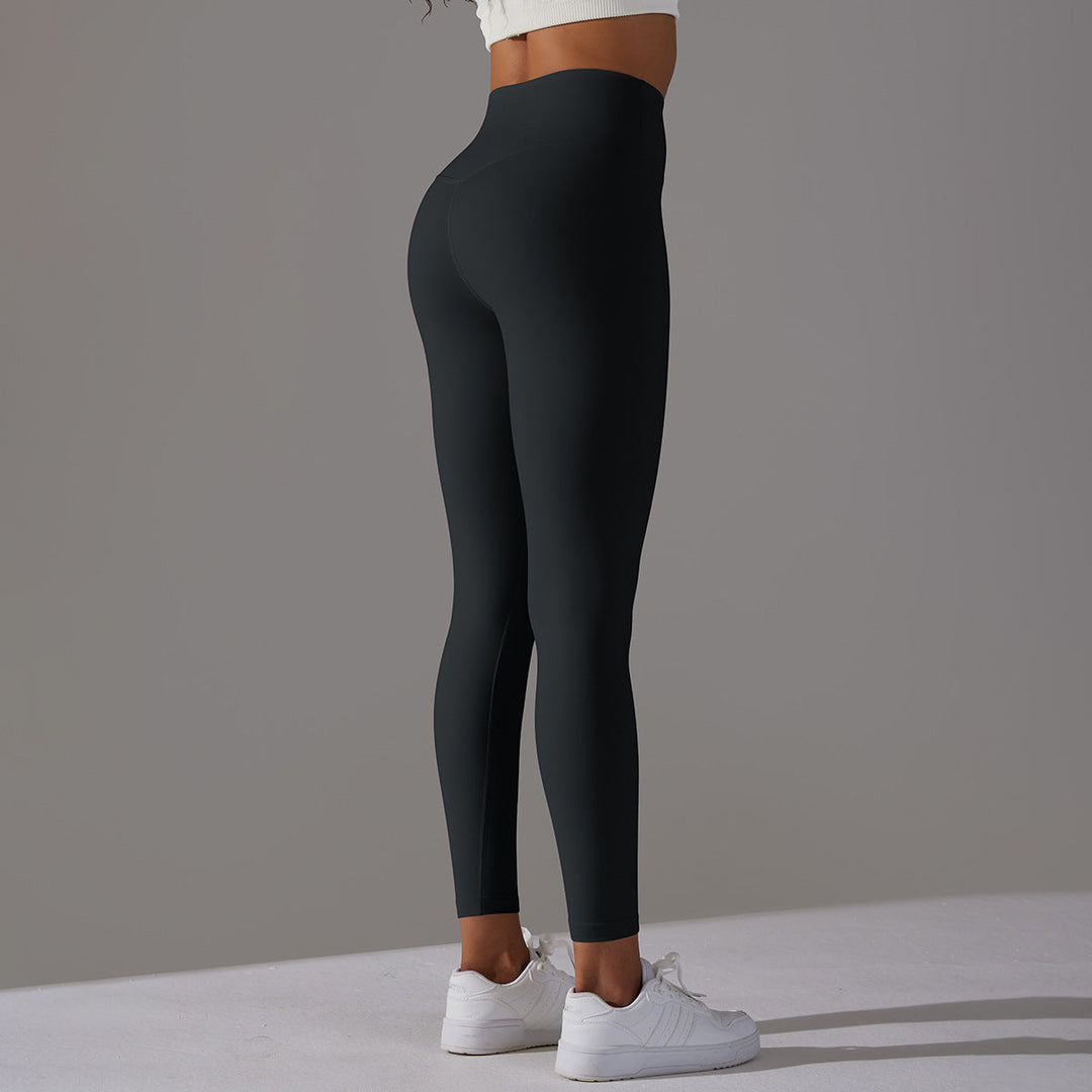 Femme en leggings de sport taille haute, idéaux pour le yoga, la gym ou l'entraînement athlétique.