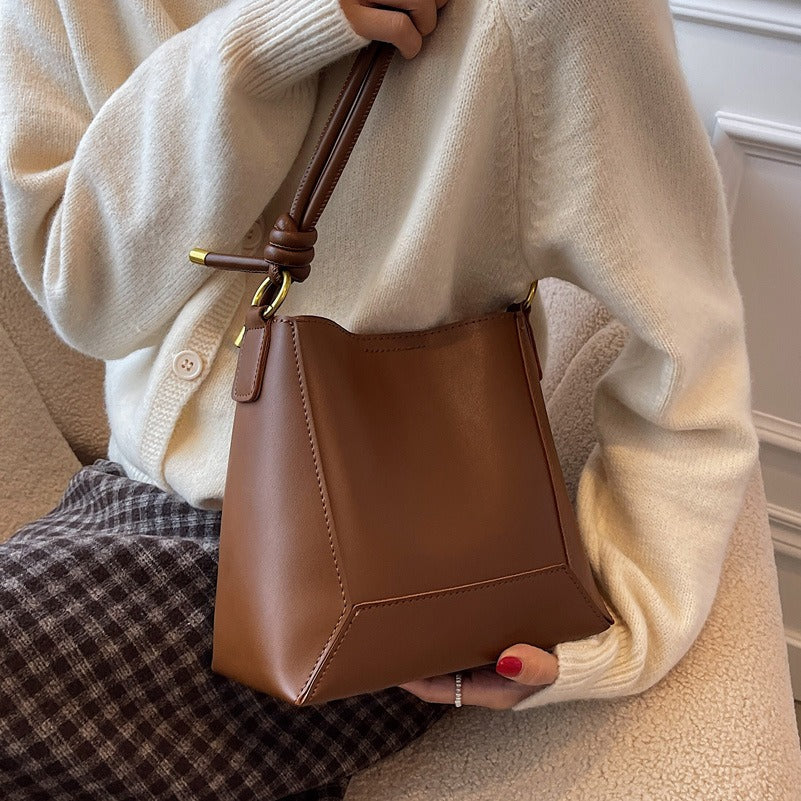 Élégant sac seau minimaliste en cuir synthétique, parfait pour la femme moderne et chic. Mode intemporelle.