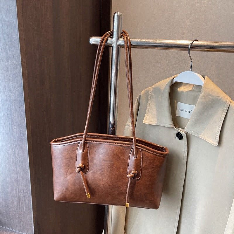 Sac à main femme structuré en cuir synthétique de qualité, bandoulière ajustable, look intemporel.