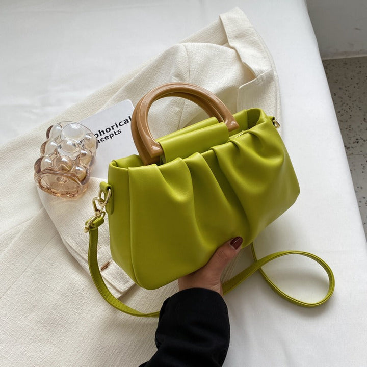 Sac à main femme élégant noir avec effet volanté moderne et bandoulière chic, un accessoire tendance.