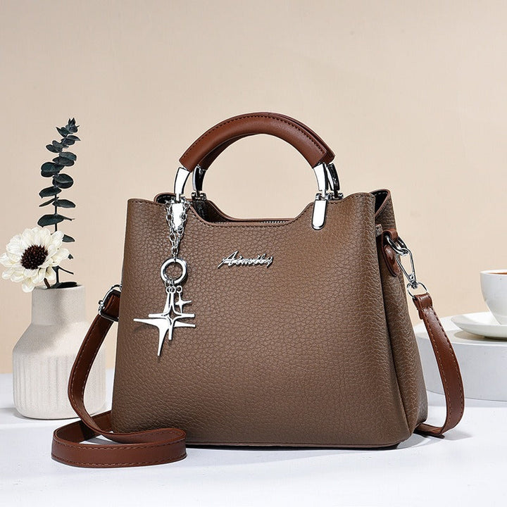 Sac à main femme élégant en simili-cuir avec détail pendentif, accessoire chic et polyvalent.