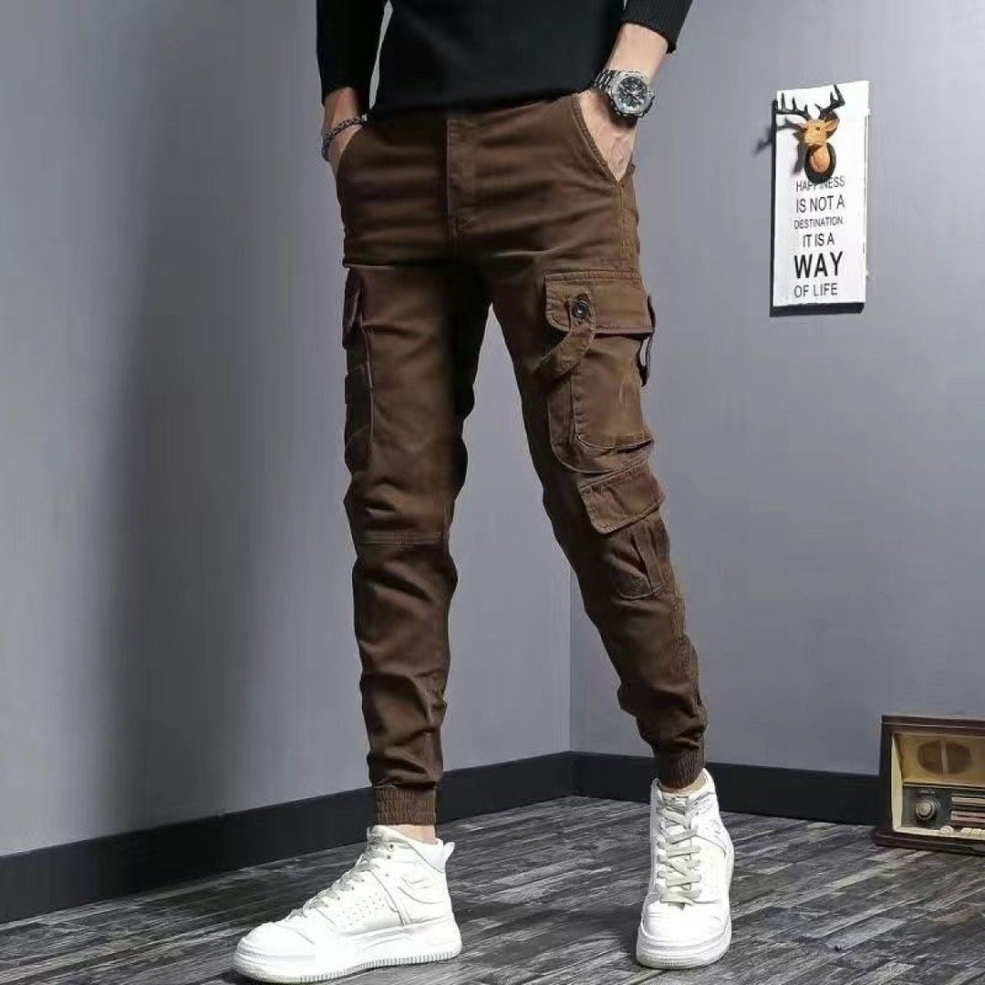 Homme portant un pantalon cargo slim fit noir, affichant une coupe ajustée et des poches latérales stylées.