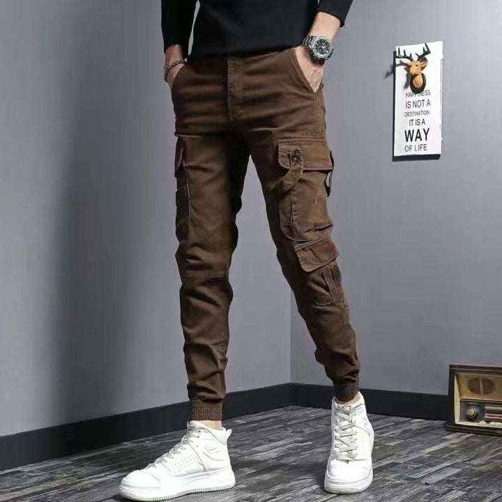 Homme portant un pantalon cargo slim fit noir, affichant une coupe ajustée et des poches latérales stylées.