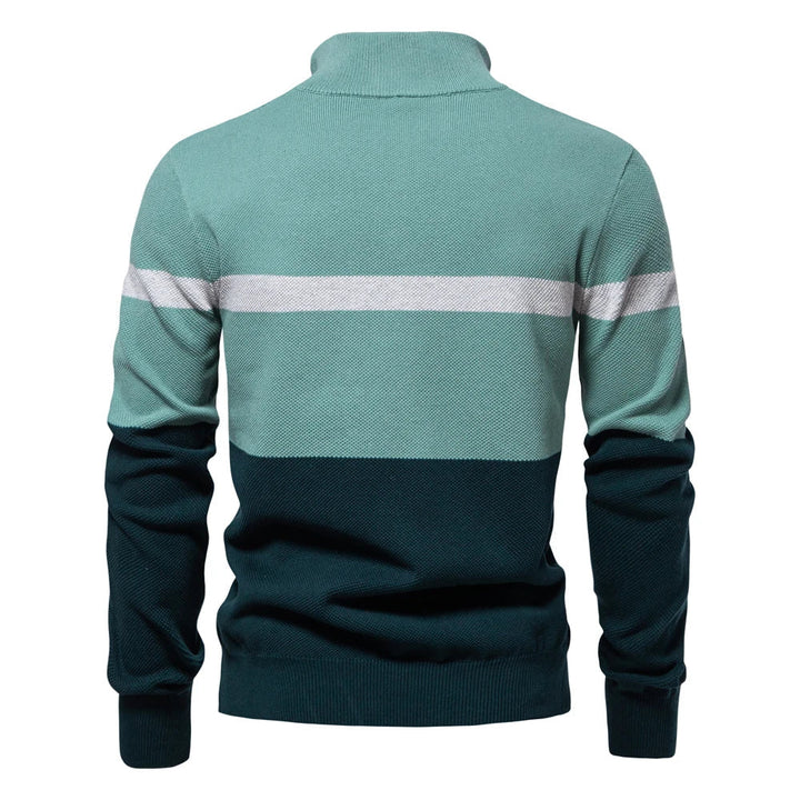 Homme portant un pull maille rayée avec col demi-zip, look tendance automne-hiver.