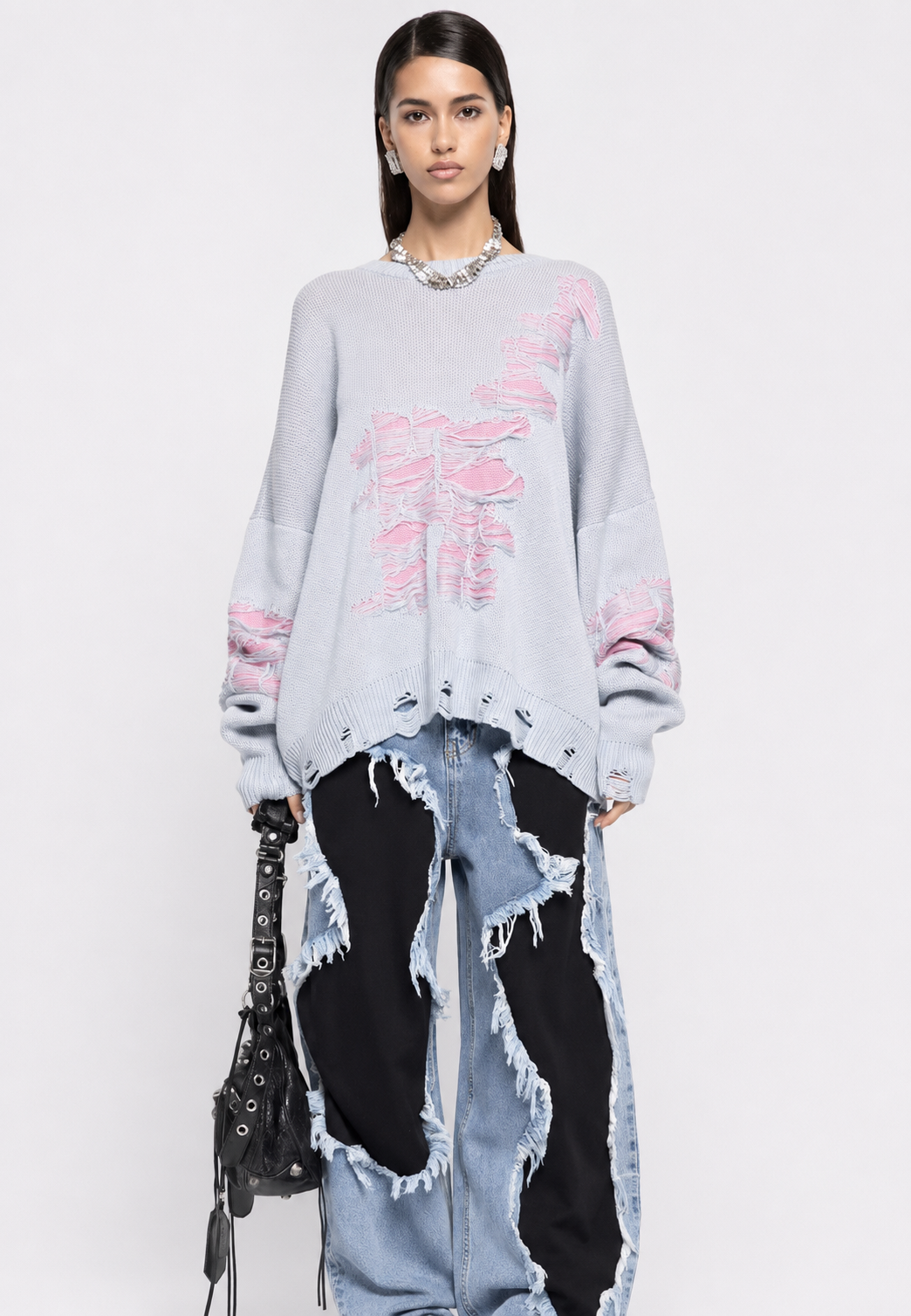Pull tendance femme, coupe oversize. Maille ajourée, déchirures discrètes, vêtement décontracté.