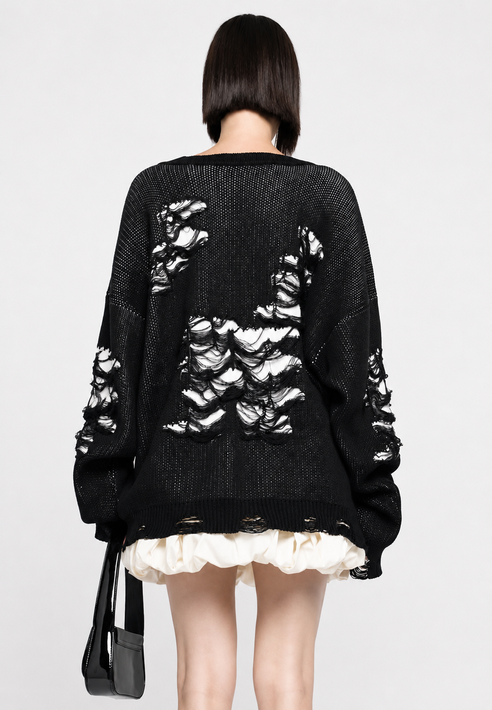 Chandail ample femme en maille ajourée. Détails déchirures stylées, vêtement hiver mode.