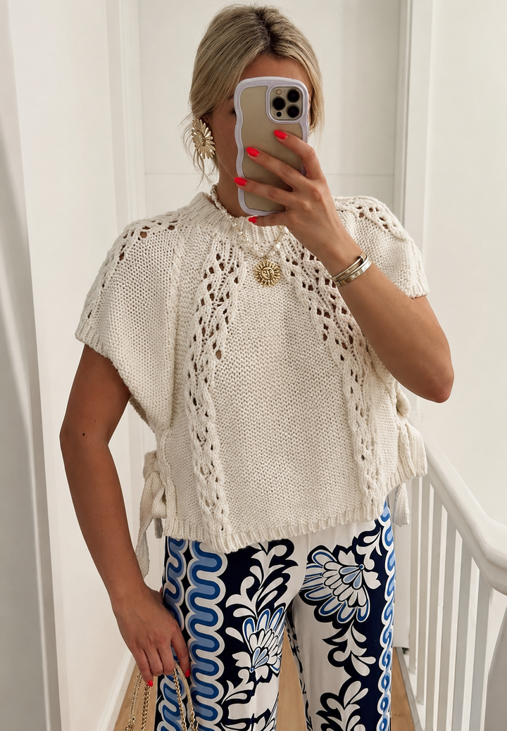 Maille ajourée blanche : pull femme à manches courtes avec nœuds latéraux. Style décontracté élégant, parfait mi-saison.