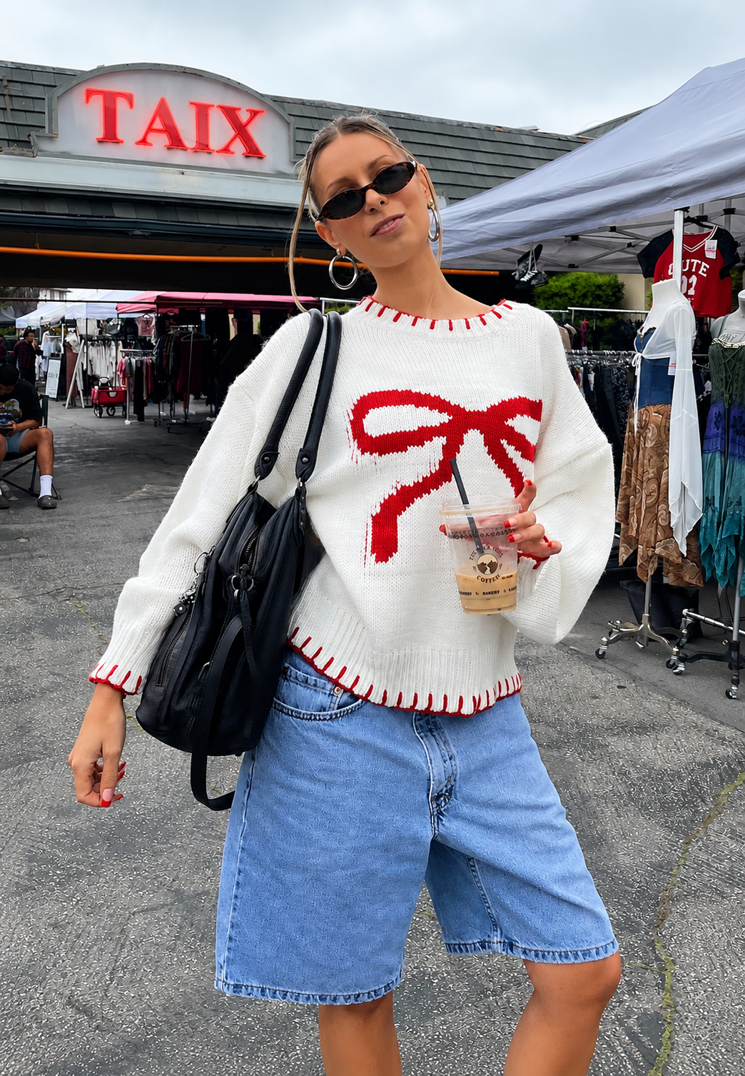 Zoom sur le motif jacquard et les nœuds décoratifs du pull oversize femme, un détail mode unique et sophistiqué.