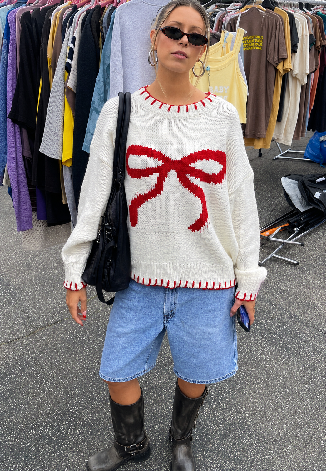 Femme élégante portant un pull oversize jacquard à nœuds, idéal pour un look décontracté-chic et confortable d'hiver.