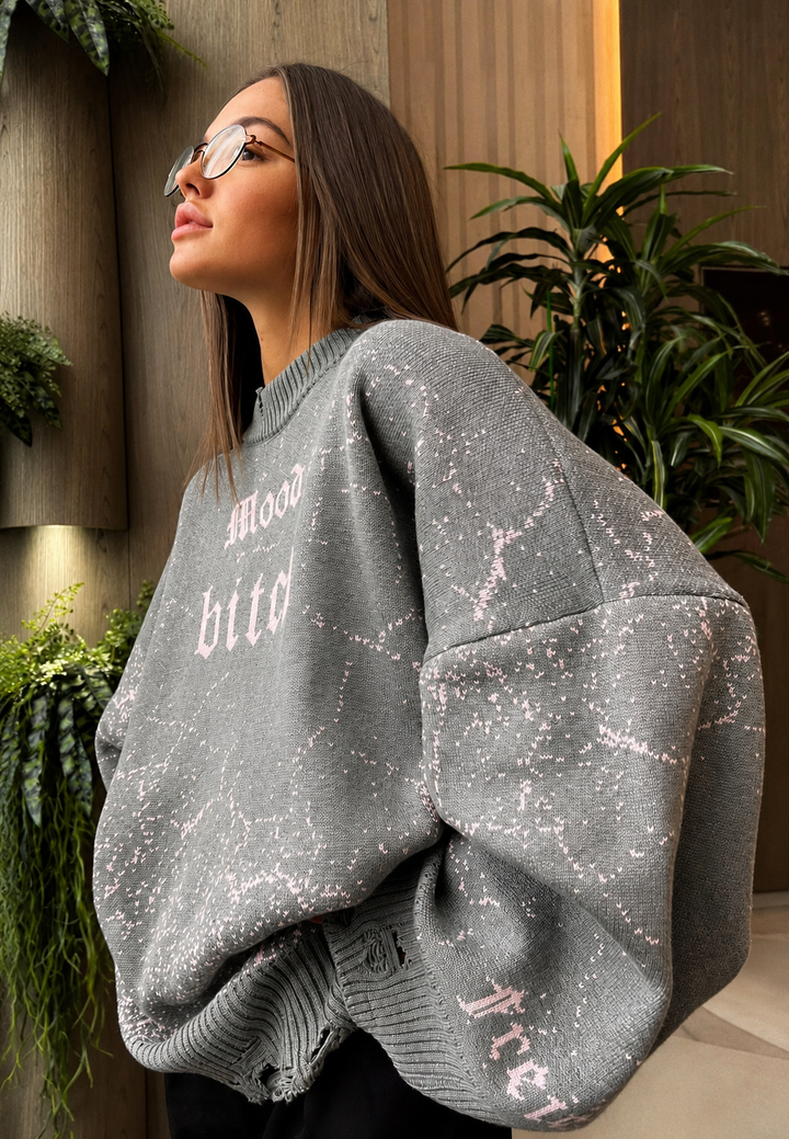 Magnifique pull femme oversize à motifs graphiques et bords déchirés pour l'automne chic.