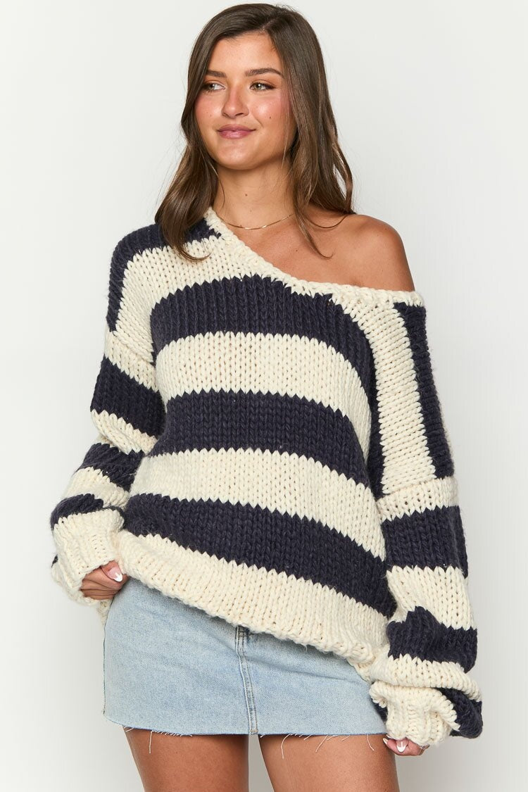 Pull à rayures pour femme, coupe oversize et épaules dénudées. Un vêtement chic et confortable.