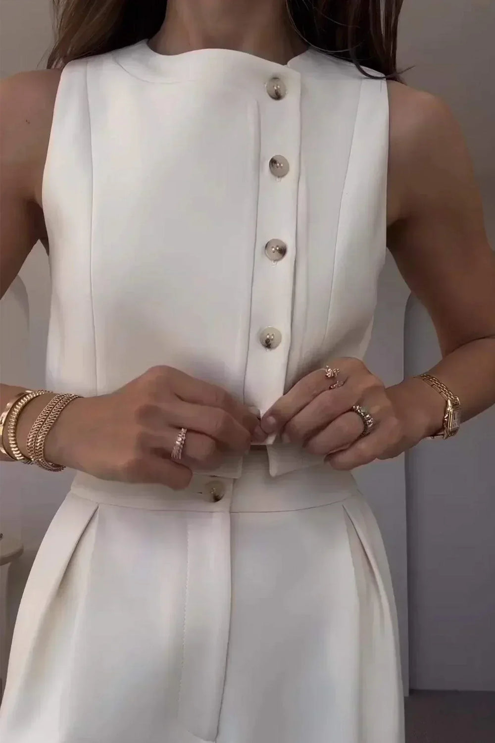 Détail de l'ensemble structuré blanc femme : texture du gilet chic et coupe élégante du pantalon. Style mode polyvalent.