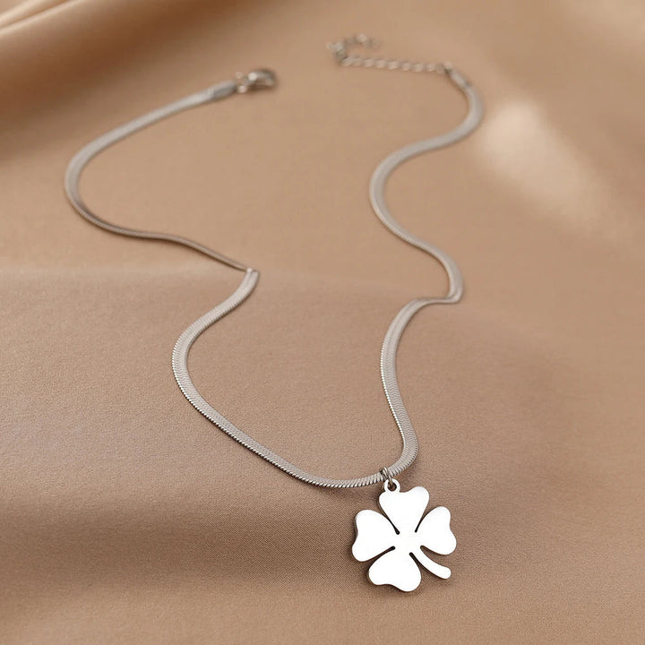 Collier pendentif trèfle en acier inoxydable porté par une femme. Bijou élégant, parfait pour cadeau.
