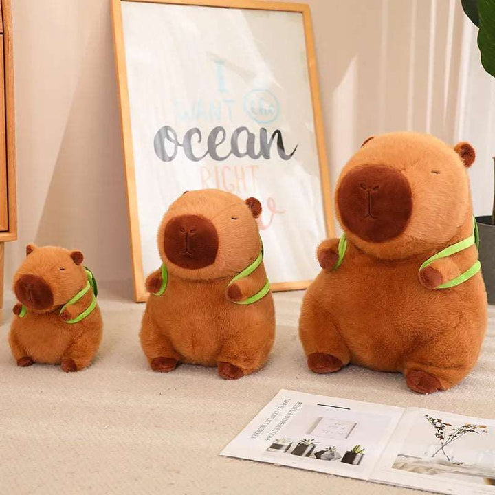 Adorable peluche capybara pour enfants, très douce au toucher, portant un mignon sac à dos en forme de tortue.