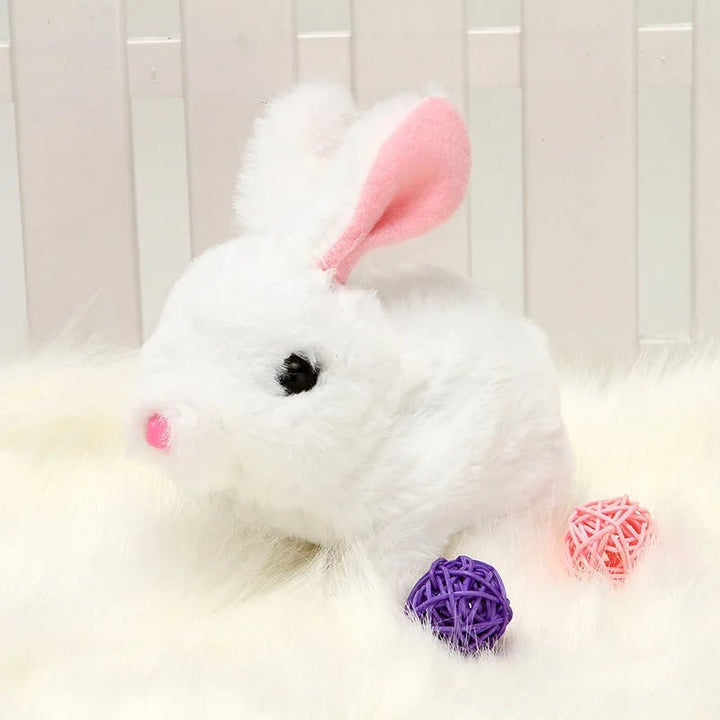 Enfant jouant avec un lapin interactif en peluche, rires garantis avec ce compagnon de jeu doux.