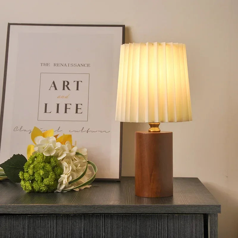 Lampe de chevet scandinave. Abat-jour plissé, base en noyer. Crée une ambiance chaleureuse avec sa lumière douce.