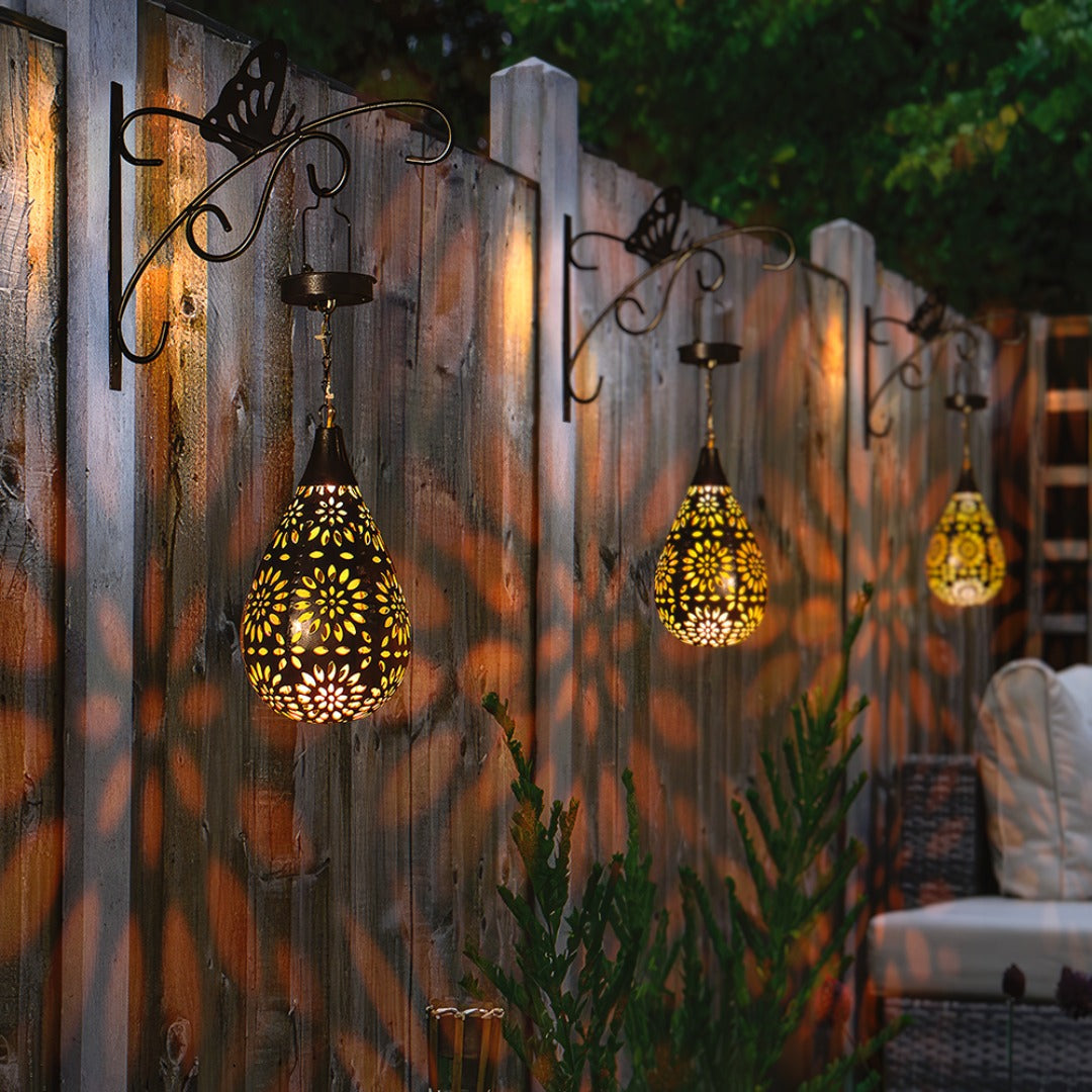 Détail d'une lampe solaire goutte d'eau allumée, offrant une lumière d'ambiance douce pour le jardin extérieur.