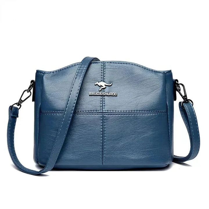 Détail du sac à main femme en cuir rouge, avec sa texture raffinée et ses finitions soignées.