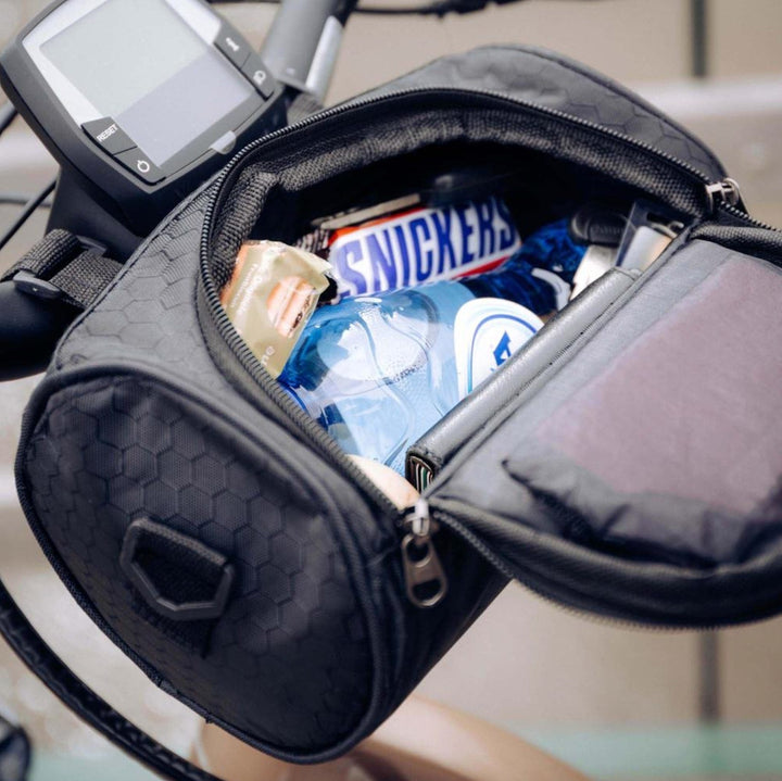 Cycliste utilisant une sacoche de guidon tactile pour consulter sa carte et ranger ses affaires.