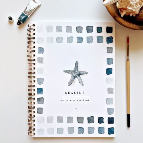 Personne utilisant le cahier d'exercices d'aquarelle, un loisir créatif relaxant et inspirant.