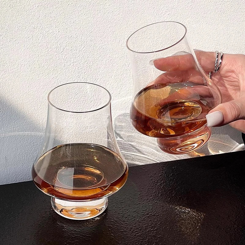 Quatre verres à whisky design, transparents, pour la dégustation, un ajout élégant à tout bar.