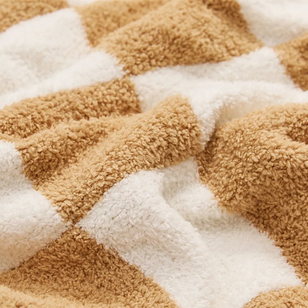 Couverture élégante à carreaux, apporte confort et style à votre décoration intérieure.