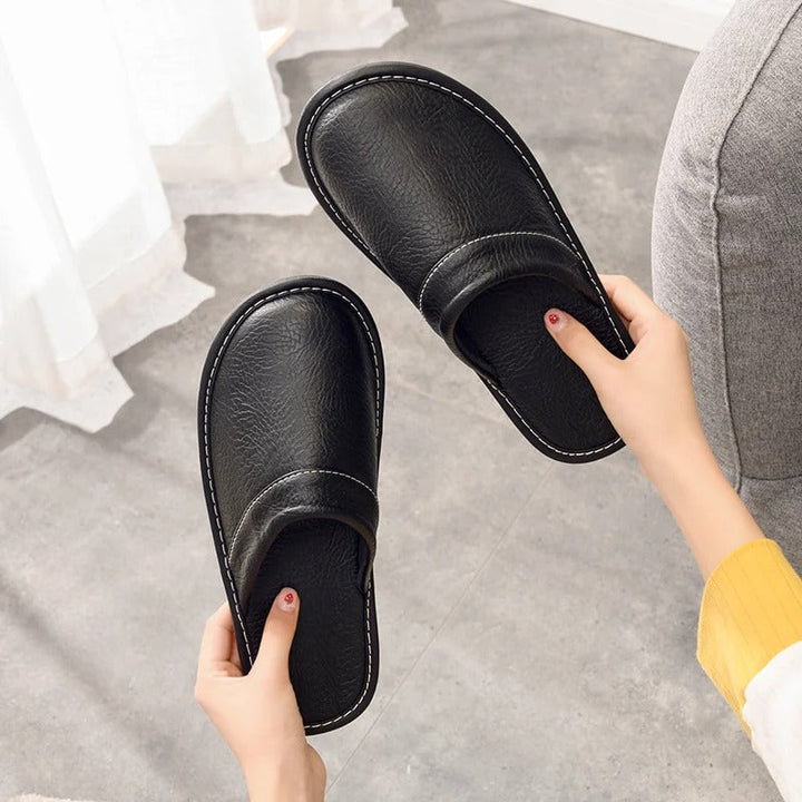 Chaussons homme en cuir noir, design raffiné, pantoufles confortables pour la détente.