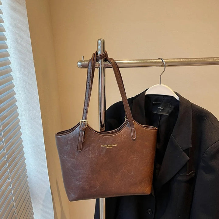 Sac à main pratique et polyvalent pour femme. Bandoulière en cuir noir, accessoire mode essentiel.