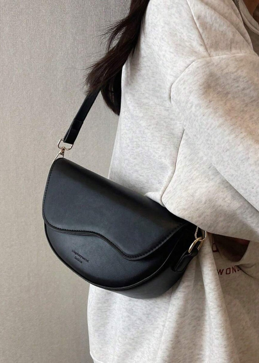 Sac femme minimaliste en cuir synthétique lisse, forme demi-lune, idéal comme sac épaule chic.