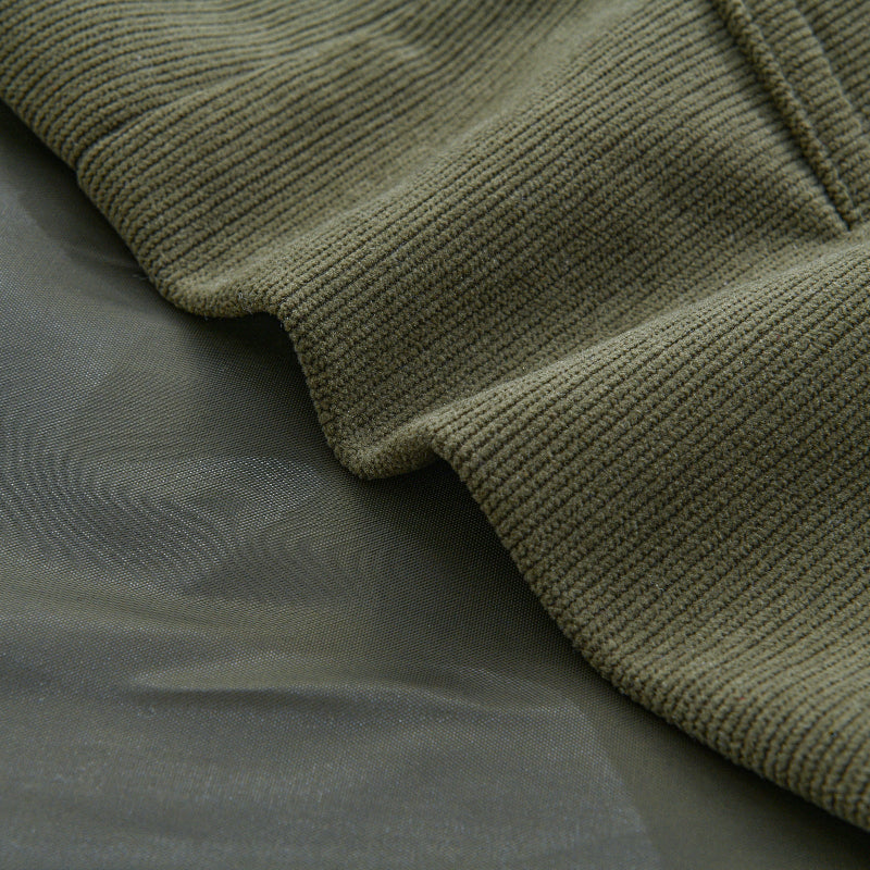 Détail du manteau homme en velours côtelé, texture riche, col montant, élégance mode masculine.