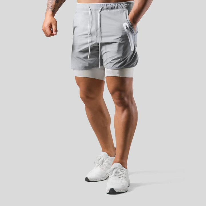 Pantalon d'entraînement homme 2-en-1, coupe moderne. Poches zippées pratiques.