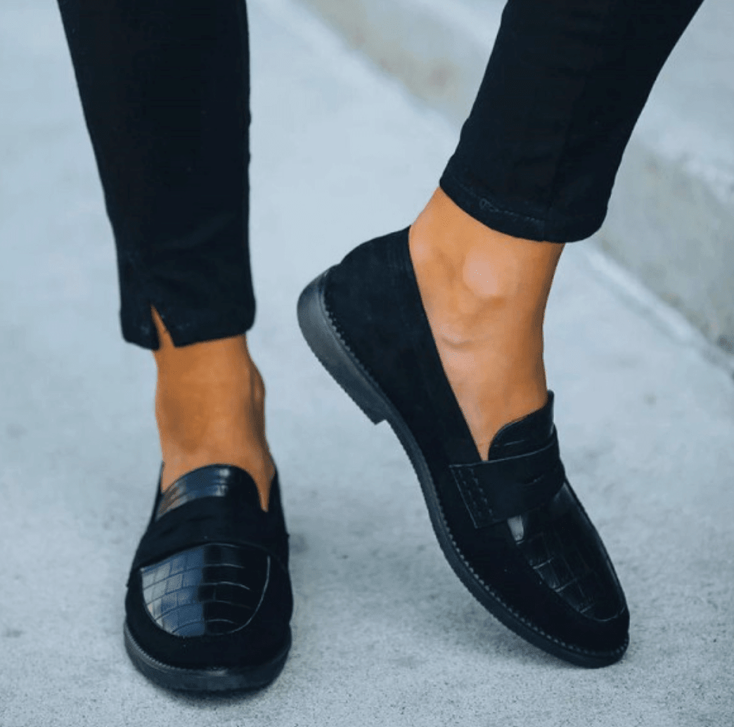 Paire de mocassins noirs femme à enfiler, en simili cuir, offrant confort et élégance décontractée.