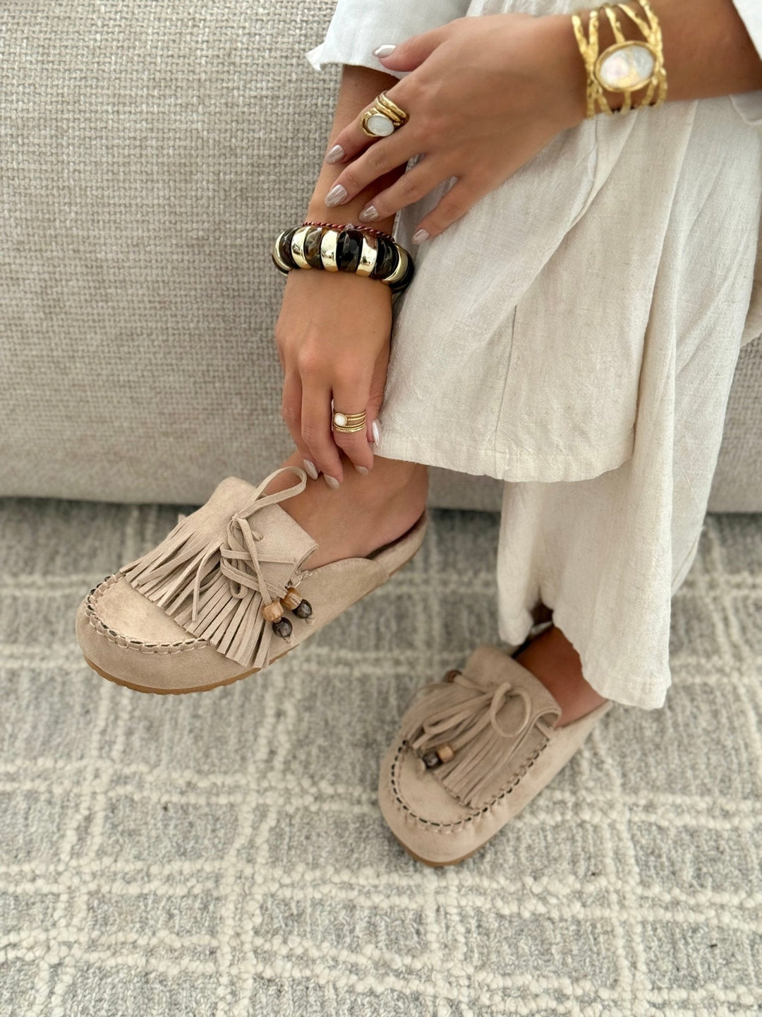 Mules plates femme avec franges et perles, un incontournable des chaussures bohèmes d'été.