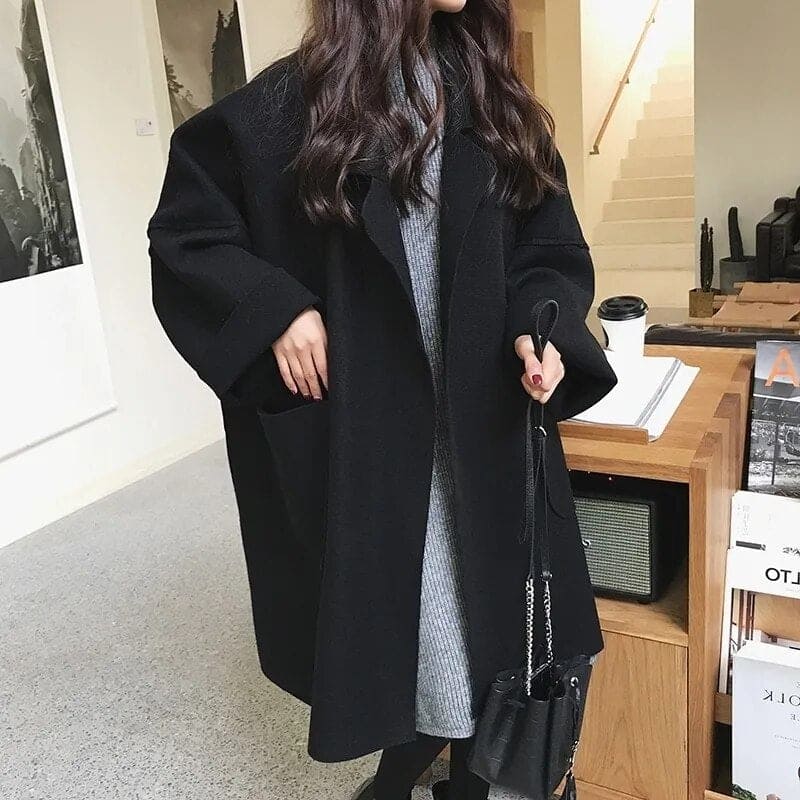 Mode femme hiver: Manteau long oversize noir, double boutonnage, ceinture. Élégant, chaud et stylé.